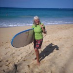 Kathryn smiling with her surfboard