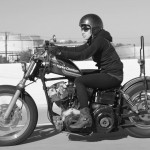 woman riding classic harley davidson motorcycle custom - brat style